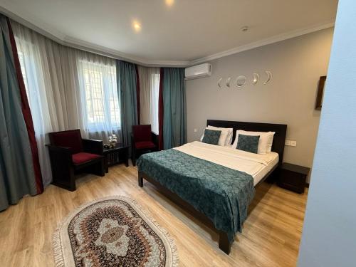 a hotel room with a bed and a chair at Vitrage Hotel Baku in Baku