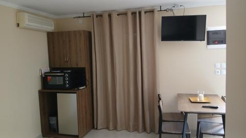 a small room with a table and a television on a wall at Villa MaryElen Marathias beach in Corfu Town