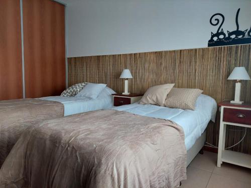 Una habitación de hotel con dos camas y dos lámparas. en Costanera, en Río Cuarto