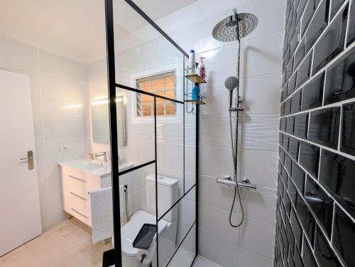 a white bathroom with a shower and a sink at Los Cristianos Sun and Relax in Tenerife