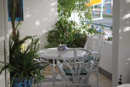 a white table and chairs with plants on a patio at Resedince Alhamra in Martil
