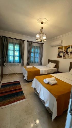 a hotel room with three beds and a chandelier at Castello Marmaris Holiday Home in Marmaris