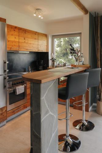 a kitchen with a counter with two bar stools at Grünten-Blick Apartment in Sonthofen