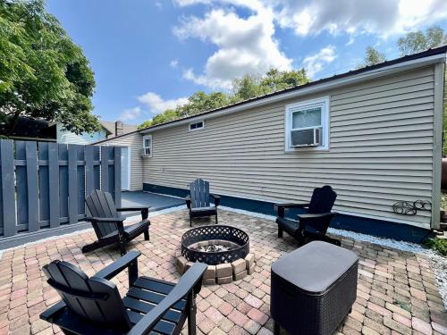 a patio with chairs and a fire pit and a building at Home in the Heart of Alex Bay Near Boldt Castle! in Alexandria Bay