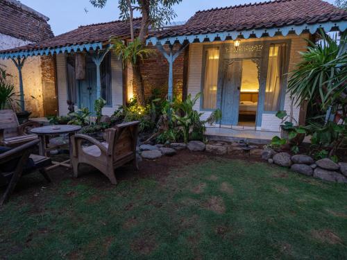 a house with a table and chairs in the yard at Happy House BnB Bromo backpacker in Probolinggo