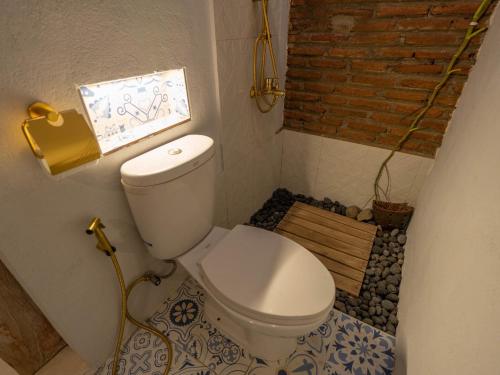 a bathroom with a toilet with a tile floor at Happy House BnB Bromo backpacker in Probolinggo