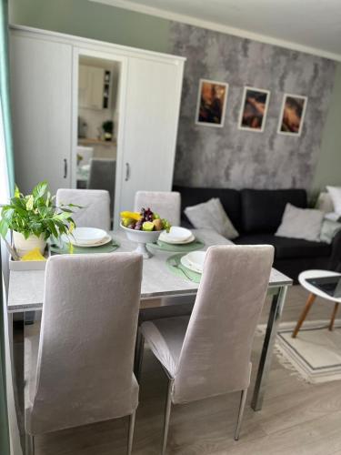 a dining room table with chairs and a living room at Apartament Piaskowa Mountain & Coffee in Wałbrzych