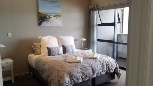 a bedroom with a bed with two trays on it at Sovereign Pier On The Waterways in Whitianga