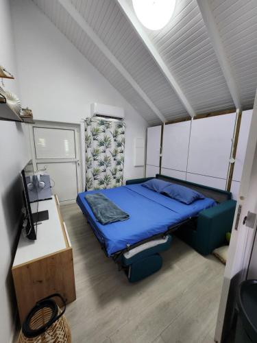 a bedroom with a blue bed and a desk at Bungalow Carioca in Le Robert