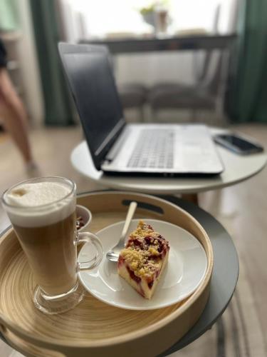 a plate of food and a cup of coffee and a laptop at Apartament Piaskowa Mountain & Coffee in Wałbrzych