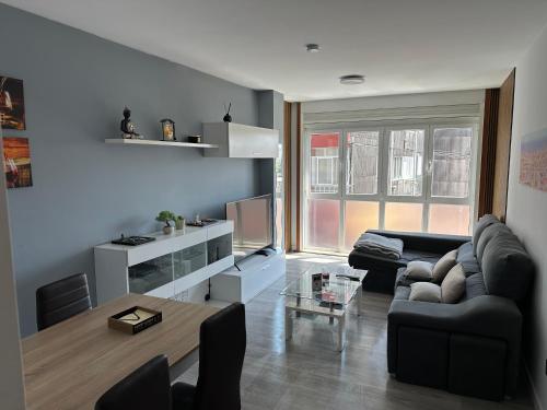 a living room with a couch and a tv at Piso camino a Fisterra in Negreira