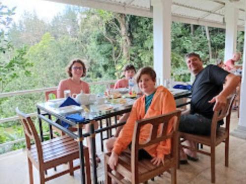 a group of people sitting at a table at Forest Edge Hotel in Ginigathena