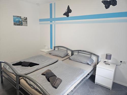 two beds in a room with butterflies on the wall at Ella's Wolke Appartements - EW6 in Zweibrücken