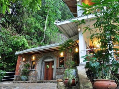 a house with plants in front of it at Forest Edge Hotel in Ginigathena