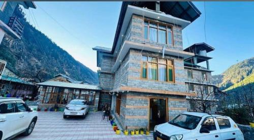 a building with two cars parked in front of it at Hotel Royal Valley in Palchān