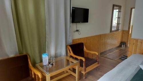 a room with a table and a chair and a tv at Hotel Royal Valley in Palchān