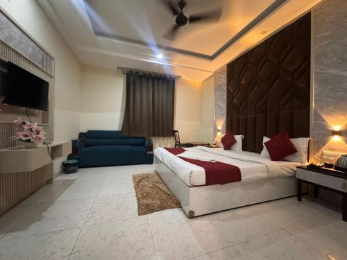 a bedroom with a bed and a blue couch at Hotel Luxury Villas Near IGI Delhi Airport in New Delhi