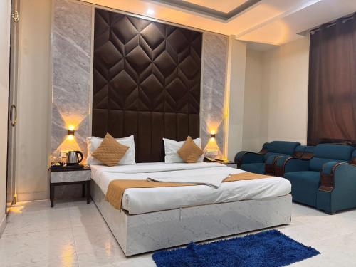 a bedroom with a king sized bed and a couch at Hotel Luxury Villas Near IGI Delhi Airport in New Delhi