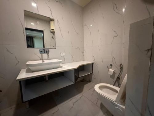 a bathroom with a sink and a toilet and a mirror at Hotel Luxury Villas Near IGI Delhi Airport in New Delhi