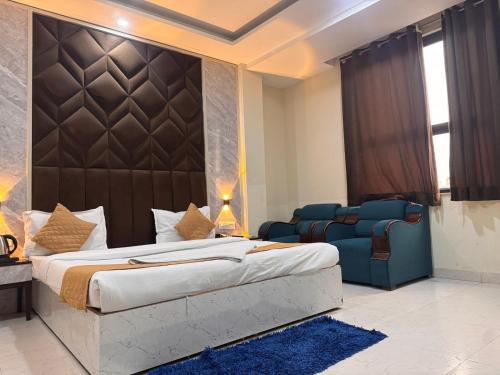 a bedroom with a large bed and a blue couch at Hotel Luxury Villas Near IGI Delhi Airport in New Delhi