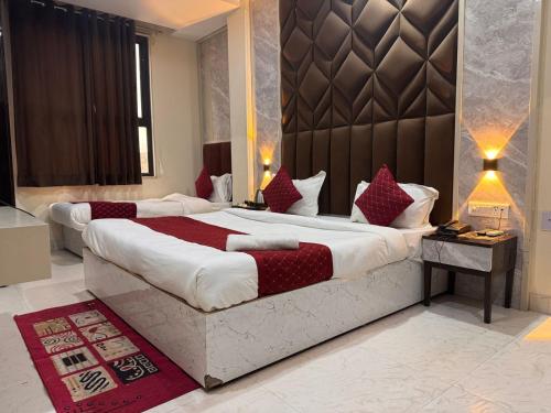 a hotel room with two beds with red pillows at Hotel Luxury Villas Near IGI Delhi Airport in New Delhi