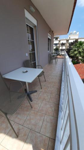 a patio with a table and chairs on a balcony at Oniro Rooms & Suites in Leptokaria