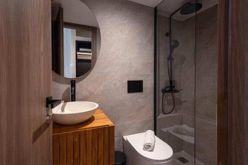 a bathroom with a sink and a mirror and a shower at Frati Villas Beachfront in Perivolos