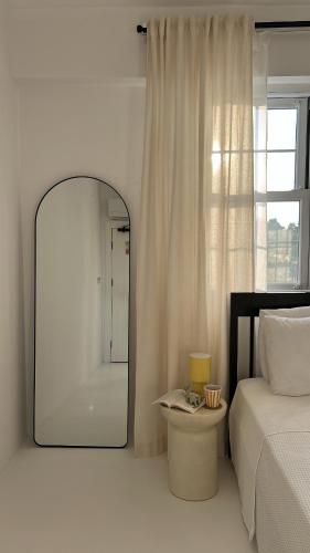 a bedroom with a mirror and a bed and a window at Cedori Butik Otel in Ezine
