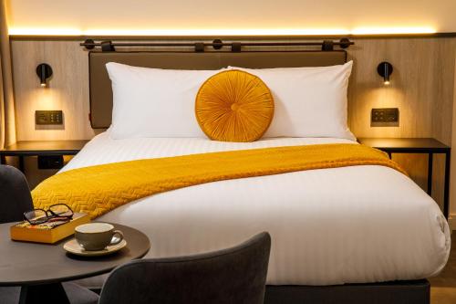 a bedroom with a large bed and a table at Southgate Hotel London in East Barnet