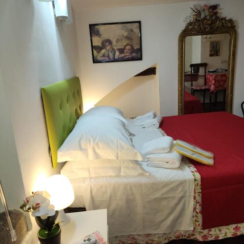 a bedroom with a bed with white sheets and a mirror at Appartamento Girasole in Florence