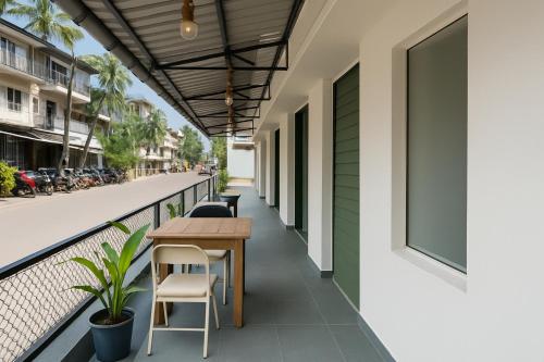 a balcony with a table and chairs on a building at Traveler Baga Beach House in Baga