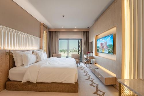 a bedroom with a large bed and a large window at World Heart Hotel in Baghdad