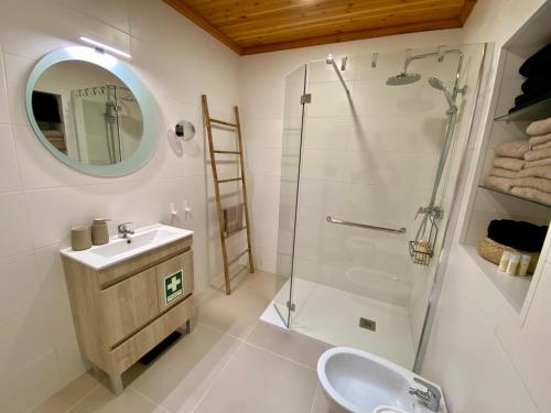 un bagno con doccia, lavandino e specchio di Pura Vida a Lomba da Maia