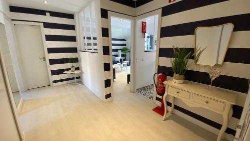 un couloir avec des murs rayés noir et blanc et un miroir dans l'établissement Blue Beach Home with Terrace, à Albufeira