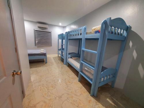 2 blauwe stapelbedden in een kamer met een gang bij Denzel's Cosy Inn in San Juan