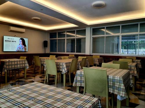 een eetkamer met tafels en stoelen en een scherm bij Denzel's Cosy Inn in San Juan