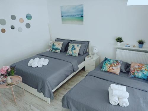 a bedroom with two beds and a table at Saturn ROOMS in Saturn