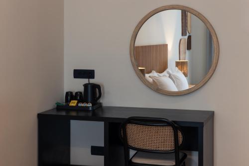 a desk with a mirror and a chair in a room at Frati Villas Beachfront in Perivolos