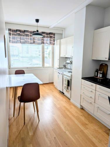 a kitchen with white cabinets and a table and chairs at Nice and cozy city apartment, free parking in Kemi