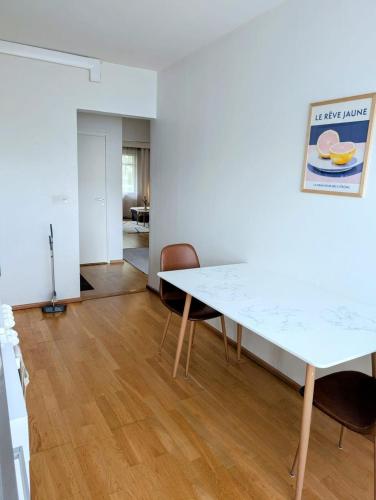 a dining room with a white table and chairs at Nice and cozy city apartment, free parking in Kemi