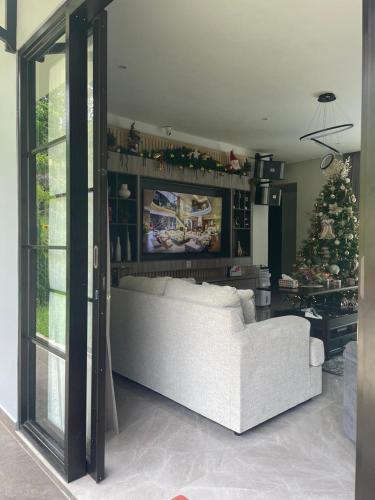 a living room with a white couch and a christmas tree at The Siburians Garden in Woloan
