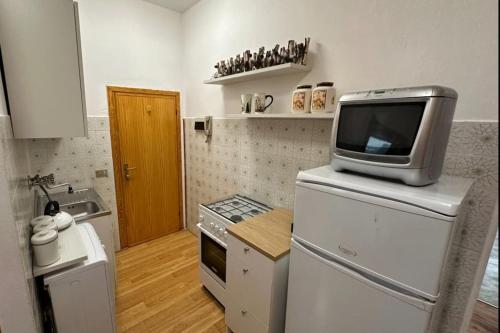a kitchen with a tv on top of a refrigerator at Favoloso alloggio a Branzi in Branzi