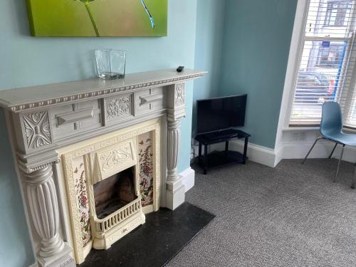 a living room with a fireplace and a television at The Town House in Whitby