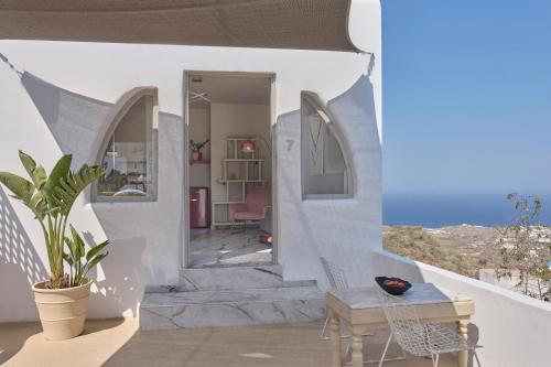 a house with white walls and a staircase with a table at Canyon Santorini in Fira