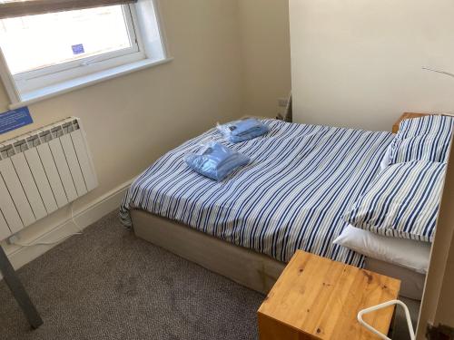 a bedroom with a bed with a blue shirt on it at The Town House in Whitby