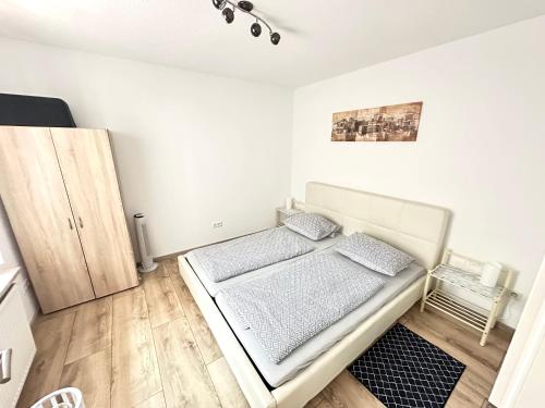 a white bedroom with a bed in a room at Ferienwohnung AyNa 1, direkt an der Schweizer Grenze in Bad Säckingen