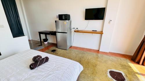 a room with a white bed and a refrigerator at IBay Samui Boutique Hotel in Plai Laem