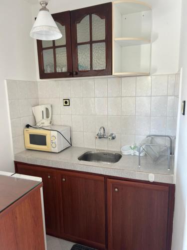 a kitchen with a sink and a microwave at КЪЩА"Перла" in Ravda