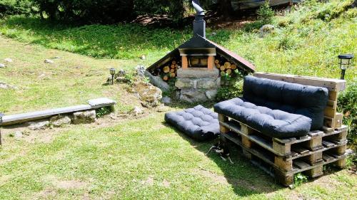a couple of chairs and a fireplace in a yard at Mayen Praz dau Lauc Charme et nature 4 personnes in Haudères