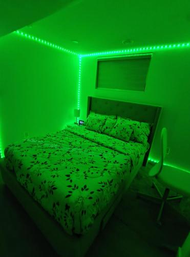 a green bedroom with a bed with a green light at ArbyManie's Place Newly Built Apartment in London